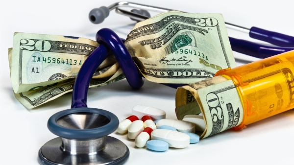 Stethoscope tied in a knot around a fist full of money