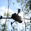 Flying drone in summer forest
