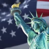 the statue of liberty with the blurry american flag waving in the background