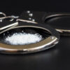 handcuffs and drugs on black table. concept arrest of drug, addiction