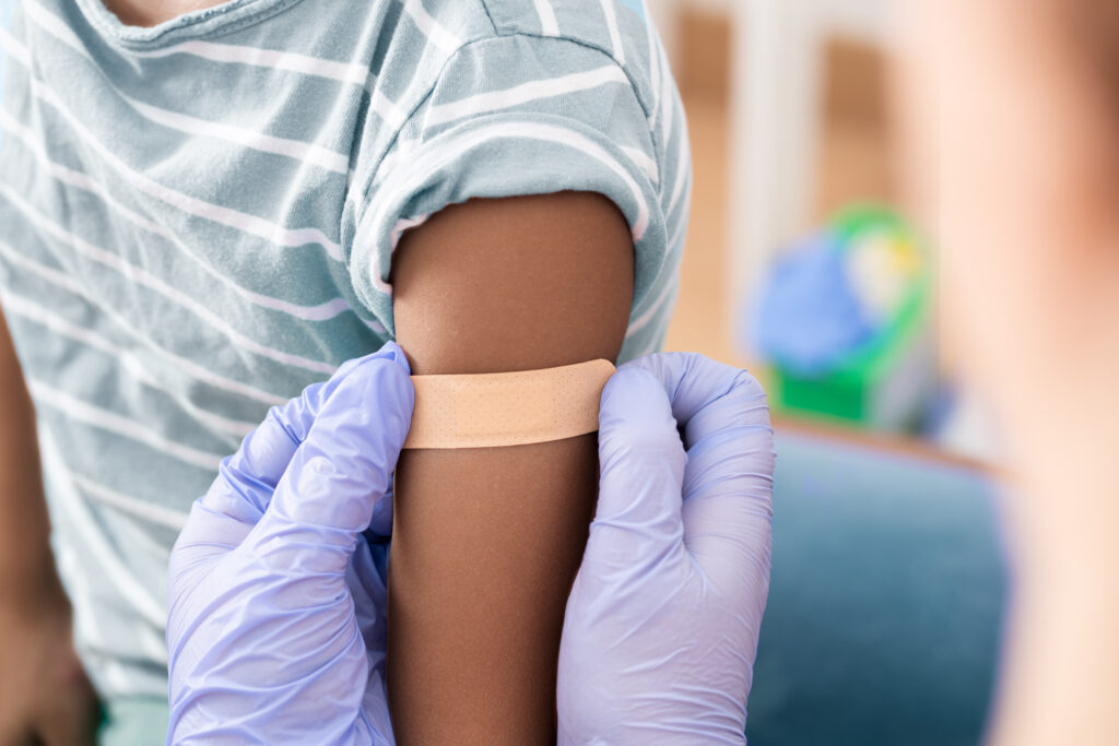 Doctor, medical and insurance with a child in a clinic for his vaccination.