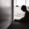 A boy looking down in a dark room.