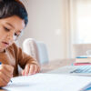 Learning headphones, math education and child in home with book for studying, homework or homeschool. Development, laptop or boy or kid with notebook for numbers in elearning, virtual or online class.