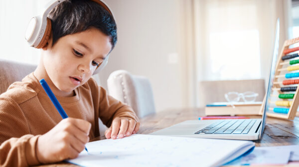 Learning headphones, math education and child in home with book for studying, homework or homeschool. Development, laptop or boy or kid with notebook for numbers in elearning, virtual or online class.